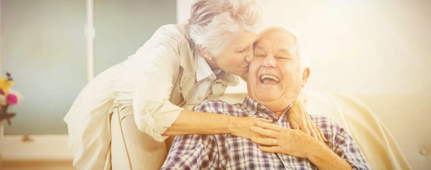 Older couple laughing together at home